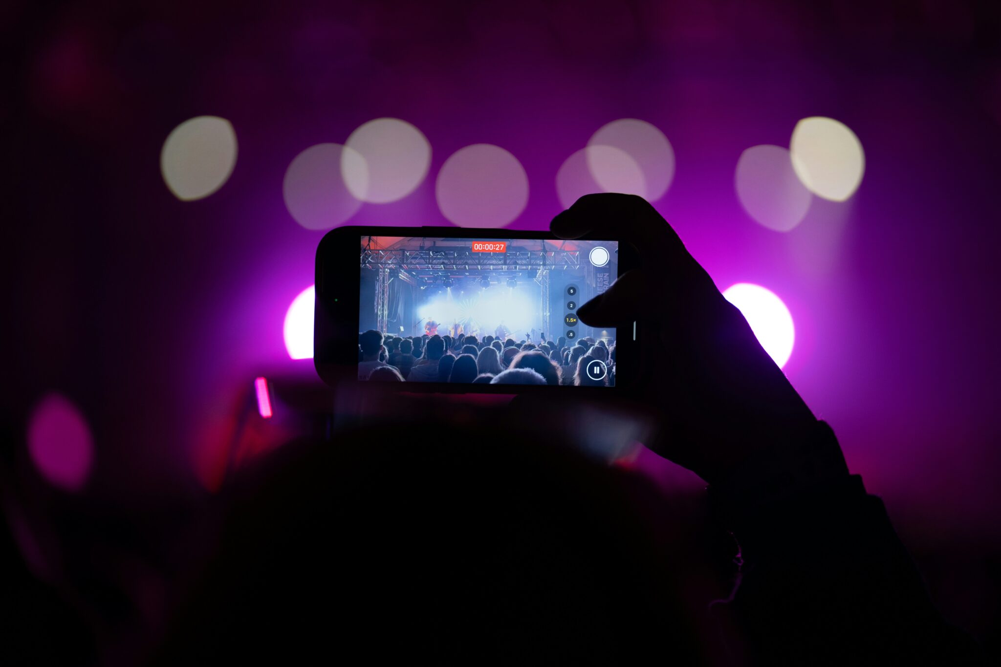 Photo of a camera phone taking a photo of an artist on stage